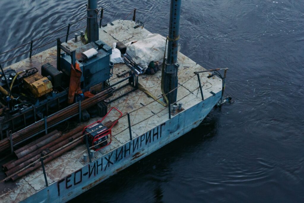 Top view of a river barge equipped with geological engineering tools and machinery.